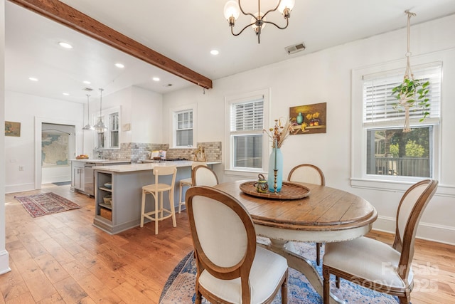 dining room featuring beam ceiling, baseboards, an inviting chandelier, and light wood-style floors