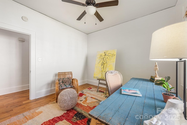 home office featuring baseboards, a ceiling fan, and wood finished floors