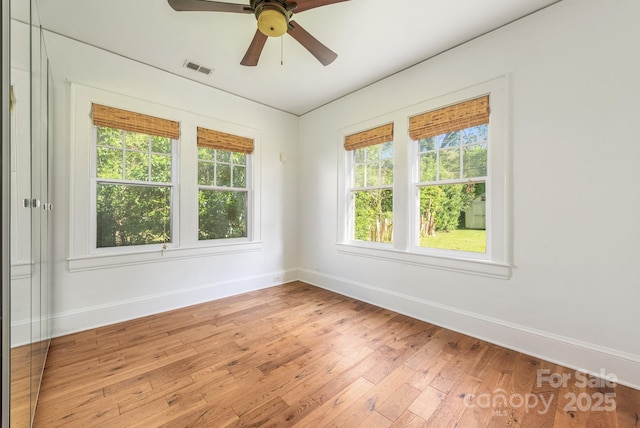 spare room featuring visible vents, baseboards, a ceiling fan, and light wood-style floors