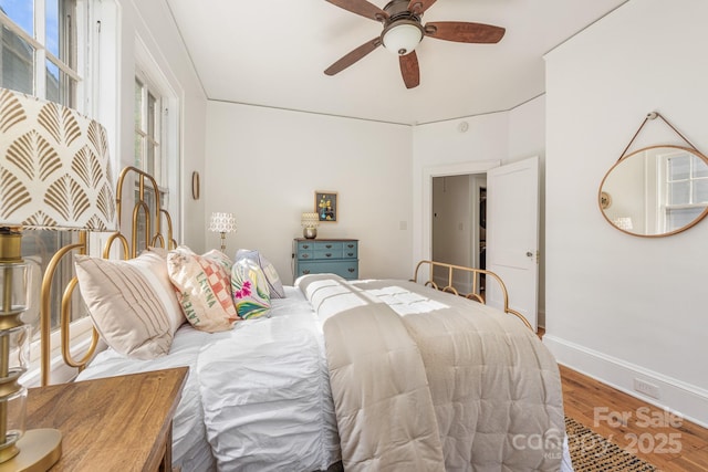 bedroom with baseboards, ceiling fan, and wood finished floors