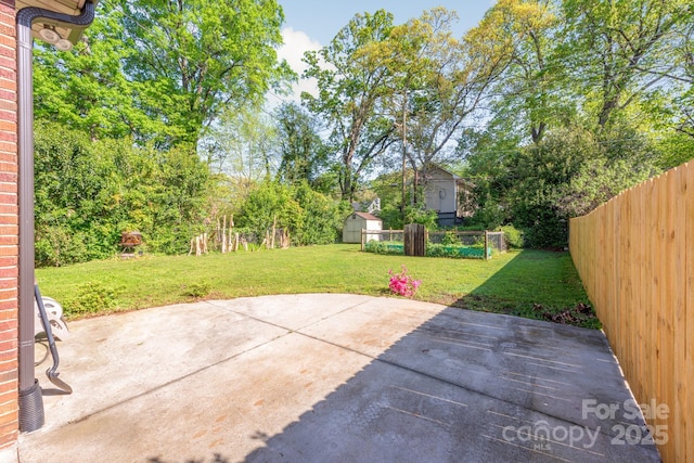 view of patio / terrace featuring an outbuilding, a fenced backyard, and a storage unit
