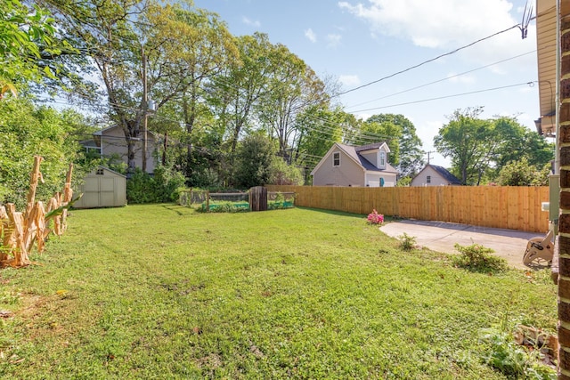 view of yard with a storage shed, a fenced backyard, an outdoor structure, and a patio