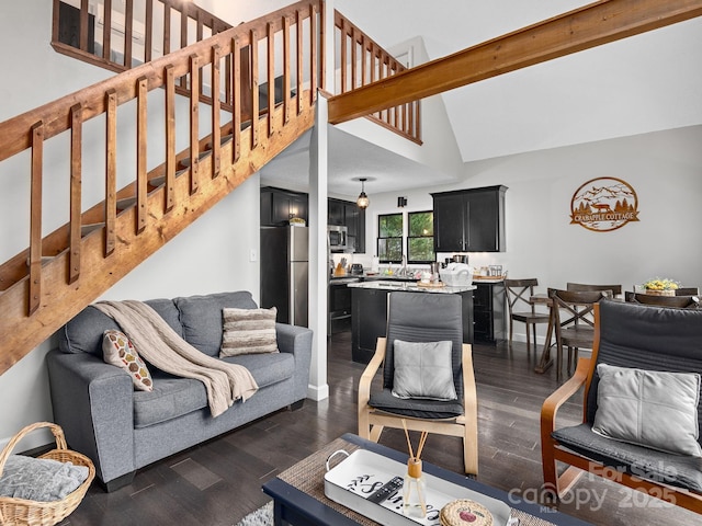 living area featuring stairs, dark wood-style flooring, and high vaulted ceiling