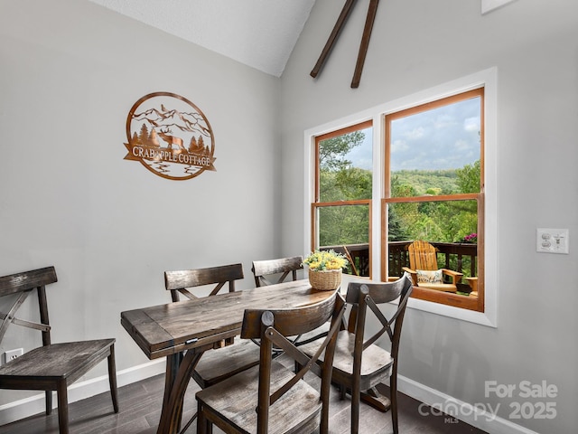 dining space featuring baseboards, vaulted ceiling, and wood finished floors