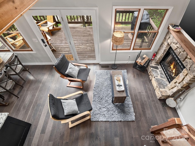 living area with baseboards, a fireplace, and wood finished floors