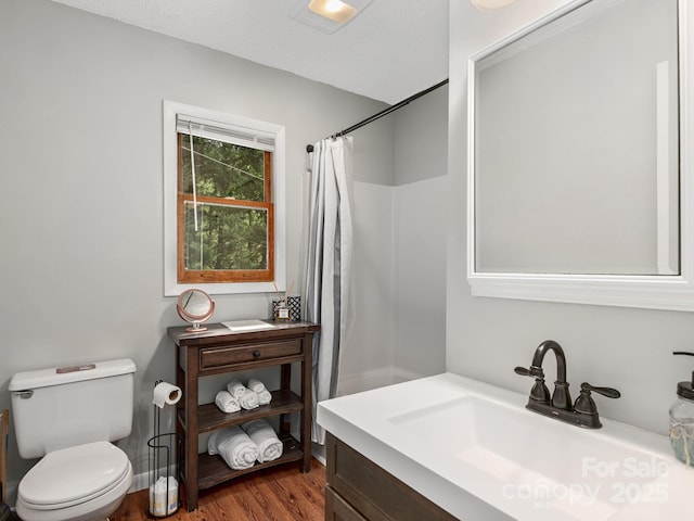 full bath featuring vanity, wood finished floors, toilet, and a shower with curtain