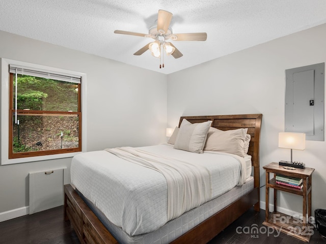 bedroom featuring a textured ceiling, a ceiling fan, baseboards, wood finished floors, and electric panel