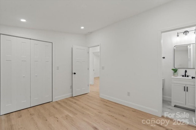3423 Archer Ave, Charlotte, NC 28217 - unfurnished bedroom featuring light wood-style floors, recessed lighting, a sink, baseboards, and a closet