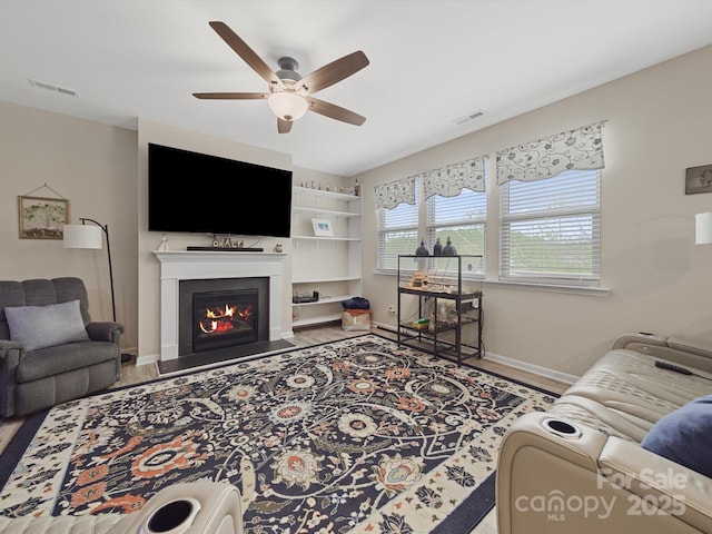807 Oak Manor Dr SE, Concord, NC 28025 - living room with a fireplace with flush hearth, visible vents, baseboards, and a ceiling fan