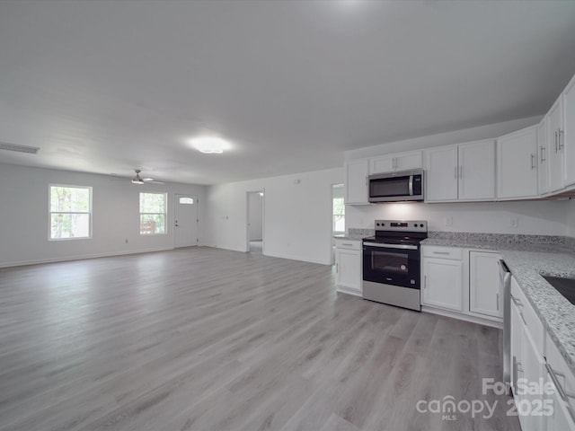 1241 Pitts Rd, Chester, SC 29706 - kitchen with white cabinets, light wood finished floors, appliances with stainless steel finishes, and open floor plan