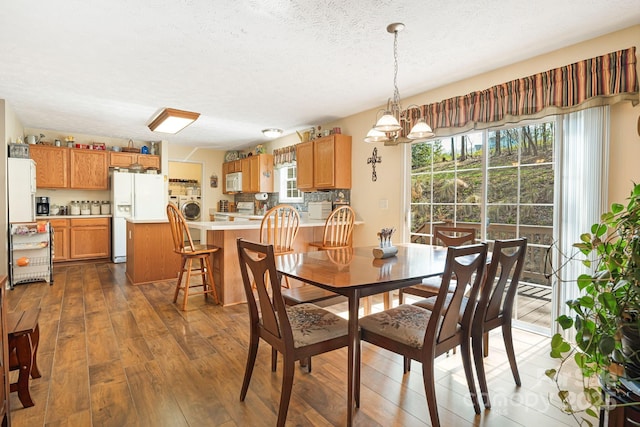 54 Golddigger Dr, Candler, NC 28715 - dining space with a healthy amount of sunlight, washer / clothes dryer, hardwood / wood-style floors, and a textured ceiling