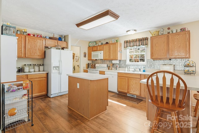 54 Golddigger Dr, Candler, NC 28715 - kitchen featuring a center island, a sink, white appliances, backsplash, and light countertops