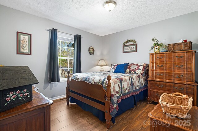 54 Golddigger Dr, Candler, NC 28715 - bedroom featuring a textured ceiling, dark wood-style flooring, and baseboards
