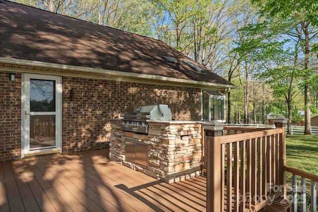 wooden deck with grilling area and an outdoor kitchen