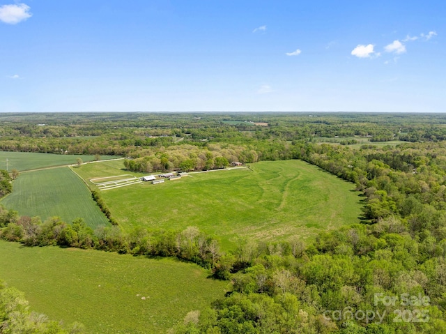 aerial view featuring a rural view and a wooded view