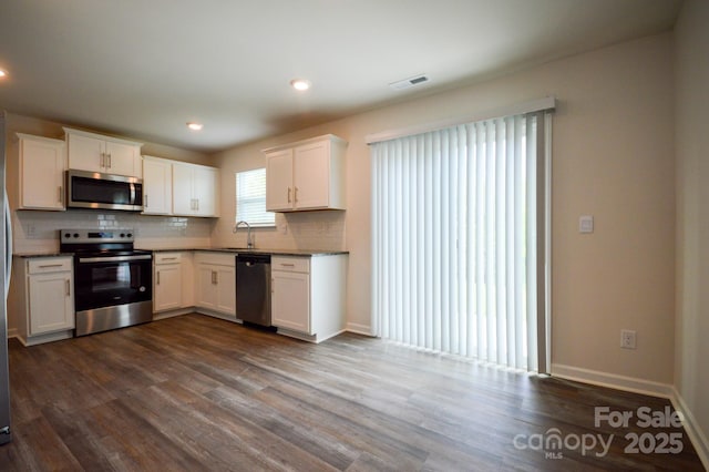52 Cain Hollow Way, Asheville, NC 28806 - kitchen with white cabinets, stainless steel appliances, dark wood-style floors, a sink, and decorative backsplash