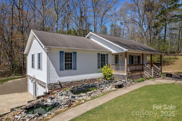 ranch-style home with a porch, roof with shingles, a front yard, an attached garage, and driveway