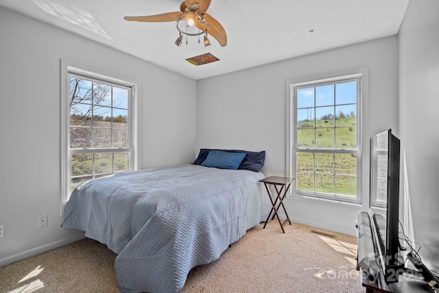 bedroom with multiple windows, baseboards, and carpet floors