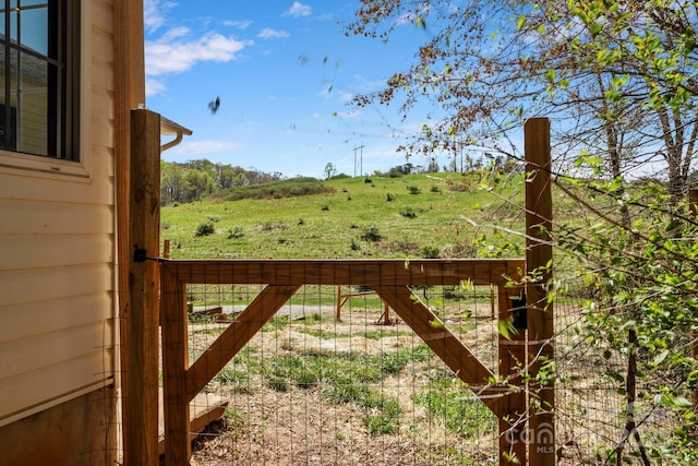 view of gate featuring a rural view and fence