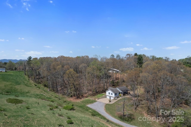 drone / aerial view with a wooded view