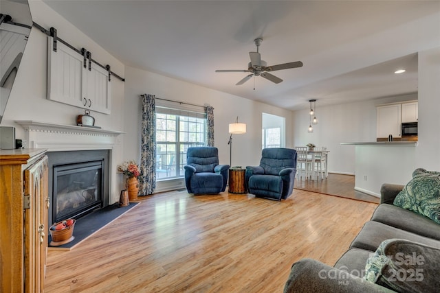 3040 Sunshower Hts, York, SC 29745 - living area with a barn door, light wood-type flooring, a glass covered fireplace, recessed lighting, and a ceiling fan