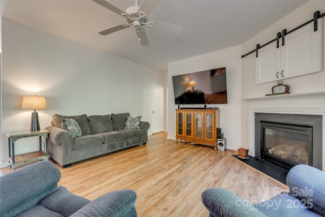 3040 Sunshower Hts, York, SC 29745 - living area with a barn door, light wood-style floors, a fireplace with flush hearth, ceiling fan, and baseboards