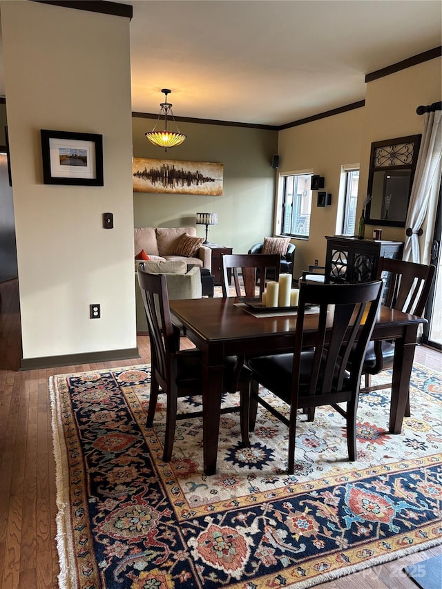 dining space featuring baseboards, hardwood / wood-style flooring, and ornamental molding