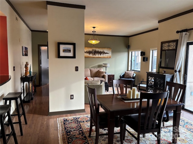 dining room with plenty of natural light, hardwood / wood-style flooring, and ornamental molding