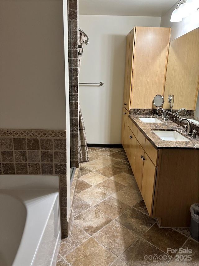 bathroom with stone finish floor, a sink, double vanity, and a stall shower