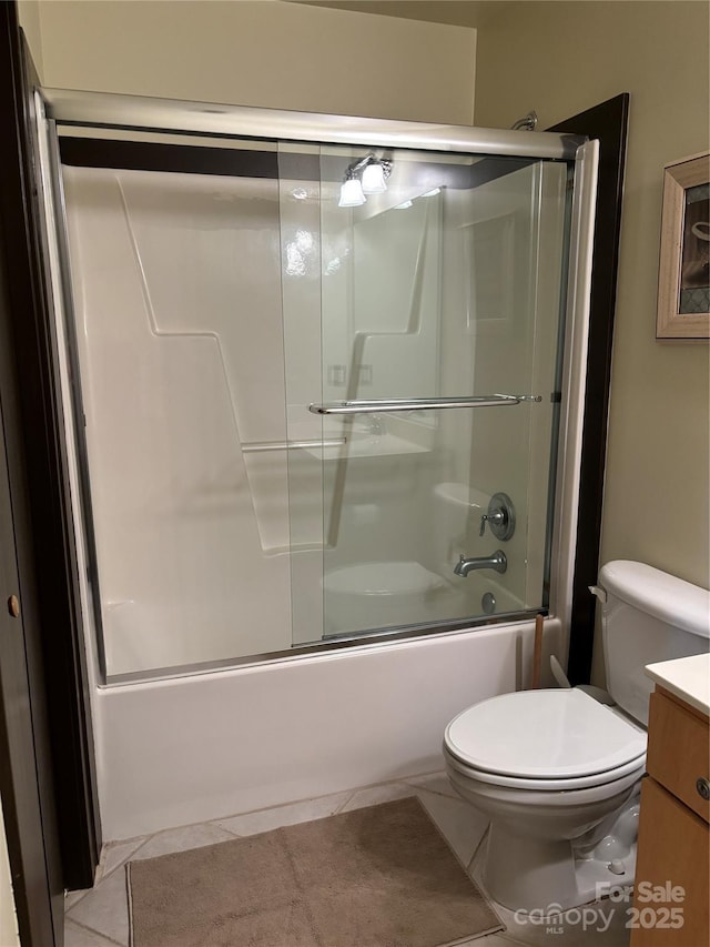 full bathroom featuring vanity, tile patterned flooring, bath / shower combo with glass door, and toilet