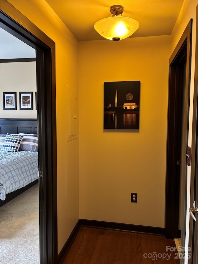 hallway with baseboards and dark wood-type flooring