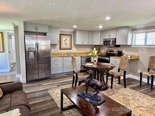 kitchen with baseboards, recessed lighting, light countertops, dark wood finished floors, and appliances with stainless steel finishes