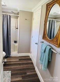 bathroom with crown molding, baseboards, curtained shower, and wood finished floors