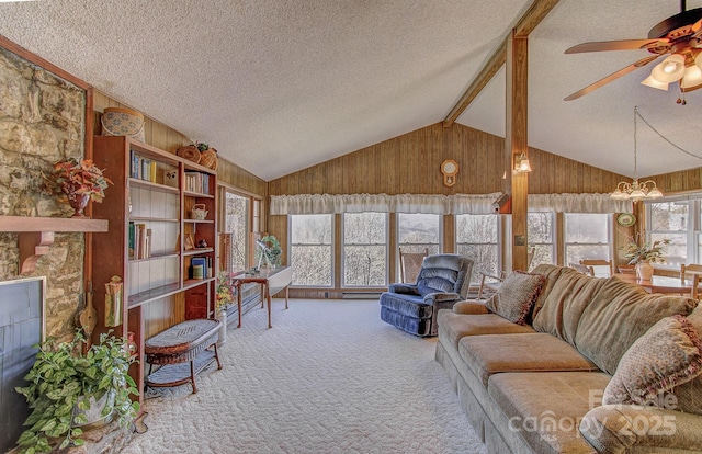 carpeted living room with a textured ceiling, wood walls, lofted ceiling with beams, and plenty of natural light