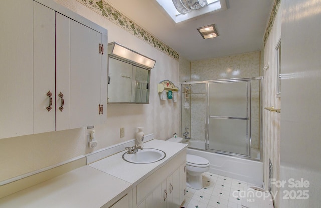 full bath featuring combined bath / shower with glass door, vanity, and toilet
