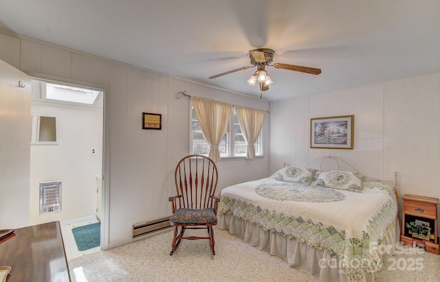 carpeted bedroom with a baseboard heating unit, a ceiling fan, and heating unit