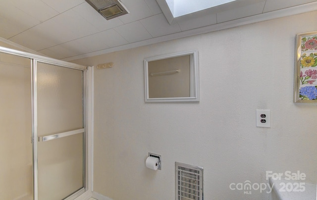 bathroom with a shower stall and visible vents