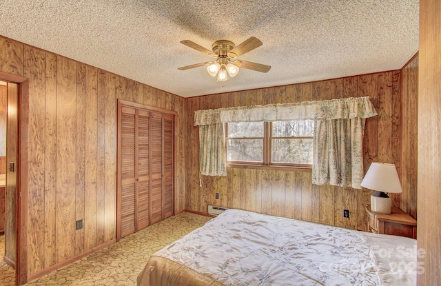 carpeted bedroom featuring a baseboard radiator, wooden walls, and a textured ceiling