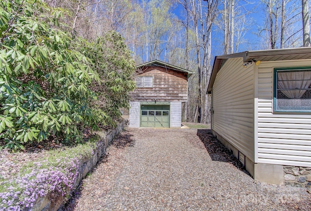 view of side of property featuring an outbuilding, driveway, and a garage