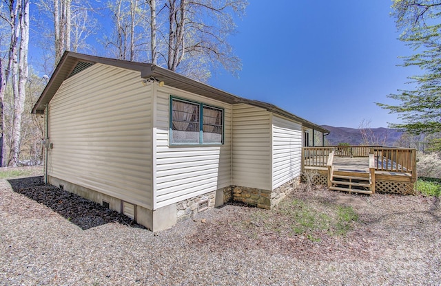view of property exterior with a deck with mountain view