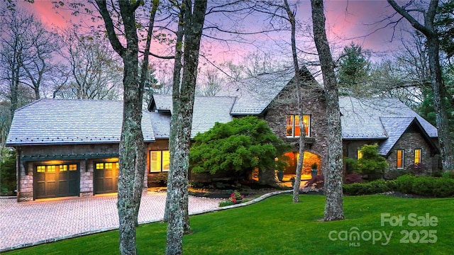 205 W Indrio Rd, Blowing Rock, NC 28605 - view of front of home with a yard, stone siding, driveway, a high end roof, and an attached garage