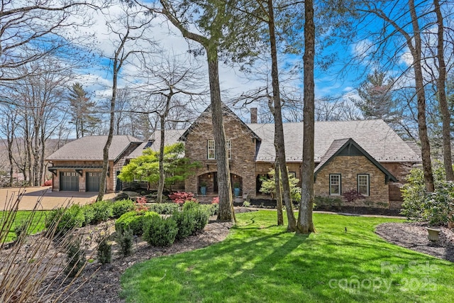 205 W Indrio Rd, Blowing Rock, NC 28605 - tudor house with stone siding, a chimney, a front yard, and driveway