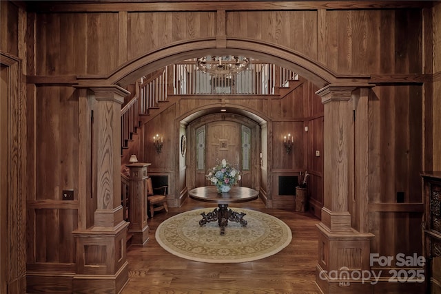 205 W Indrio Rd, Blowing Rock, NC 28605 - foyer with arched walkways, wood finished floors, stairs, wood walls, and a chandelier