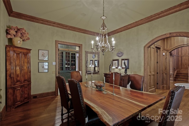 205 W Indrio Rd, Blowing Rock, NC 28605 - dining area with wood finished floors, a chandelier, baseboards, ornamental molding, and arched walkways
