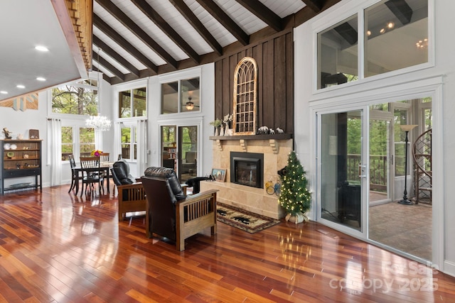 living area featuring high vaulted ceiling, a chandelier, and beam ceiling