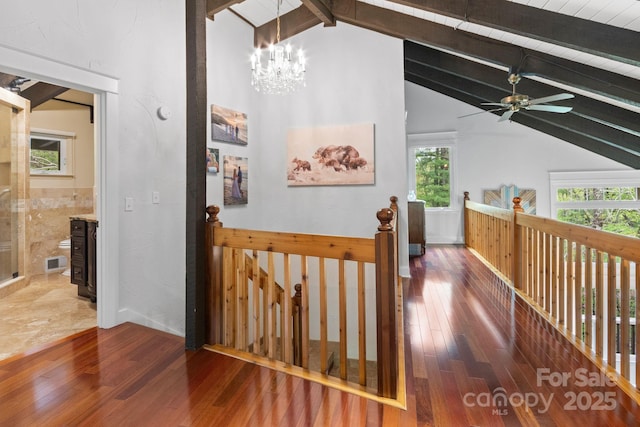corridor featuring wood-type flooring, visible vents, vaulted ceiling with beams, a chandelier, and an upstairs landing