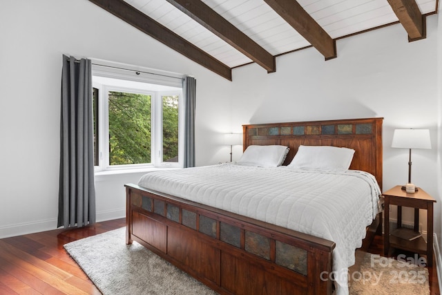 bedroom with wood-type flooring, baseboards, and vaulted ceiling with beams