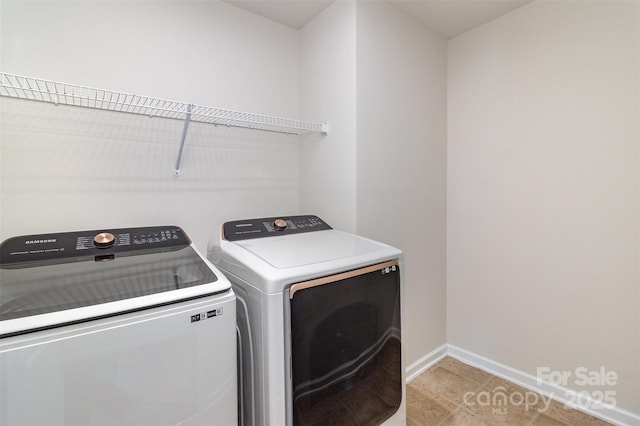 clothes washing area with washing machine and clothes dryer, laundry area, and baseboards