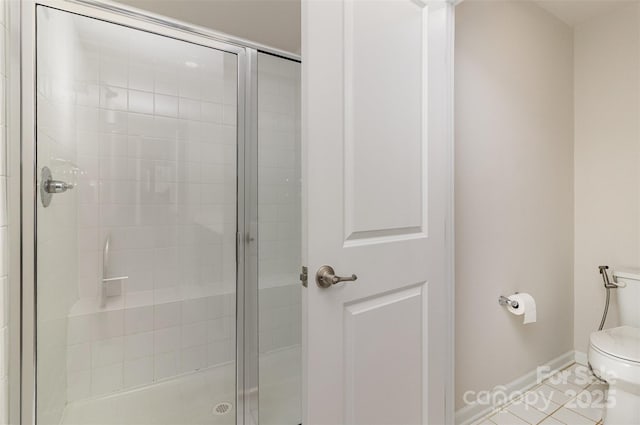 full bath featuring baseboards, a shower stall, and toilet
