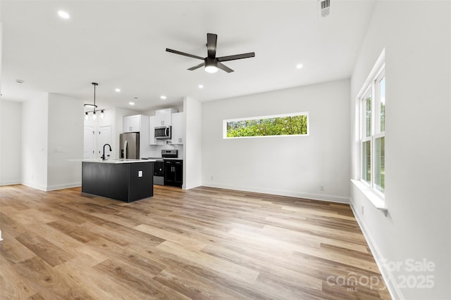 2043 Greenoak Dr, Shelby, NC 28152 - unfurnished living room featuring light wood-style flooring, ceiling fan, visible vents, and plenty of natural light